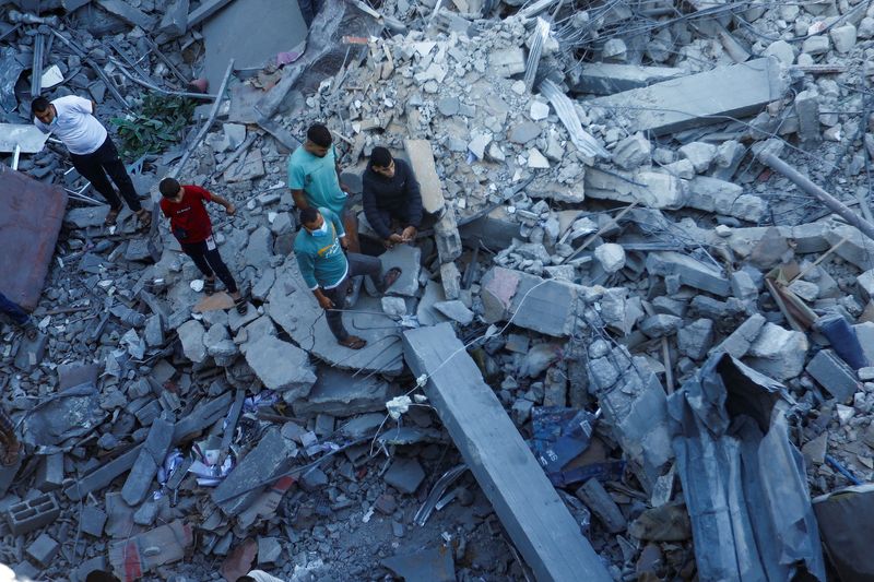 &copy; Reuters. فلسطينيون يبحثون عن ضحايا تحت الأنقاض في أعقاب غارات إسرائيلية في خان يونس بجنوب قطاع غزة يوم الجمعة. تصوير: إبراهيم أبو مصطفى - رويترز.