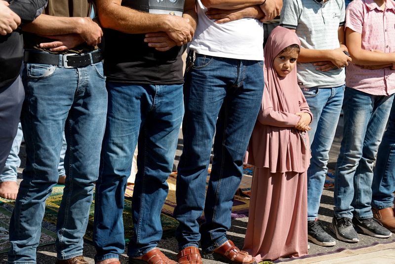 &copy; Reuters. A girl stands among men while they pray as Palestinians take part in a protest following Israeli strikes on Gaza, in Nablus, in the Israeli-occupied West Bank, October 13, 2023. REUTERS/Raneen Sawafta   