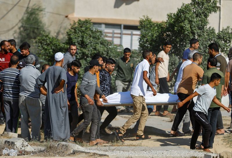 &copy; Reuters. أشخاص يحملون جثمان فلسطيني قتل جراء غارات إسرائيلية في خان يونس بجنوب قطاع غزة يوم الجمعة. تصوير: إبراهيم أبو مصطفى - رويترز.