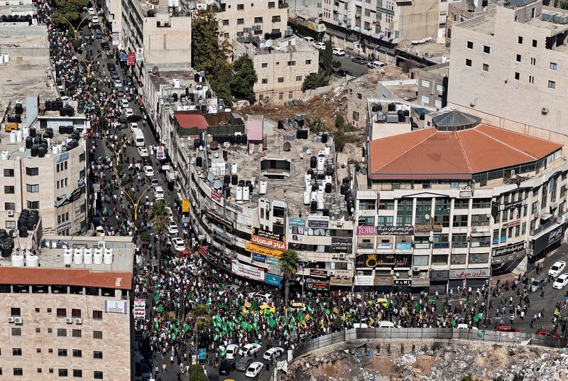 &copy; Reuters. فلسطينيون يشاركون في مسيرة احتجاجا على الغارات الإسرائيلية على غزة، في الخليل بالضفة الغربية المحتلة يوم الجمعة. تصوير: يسري الجمل - رويترز.