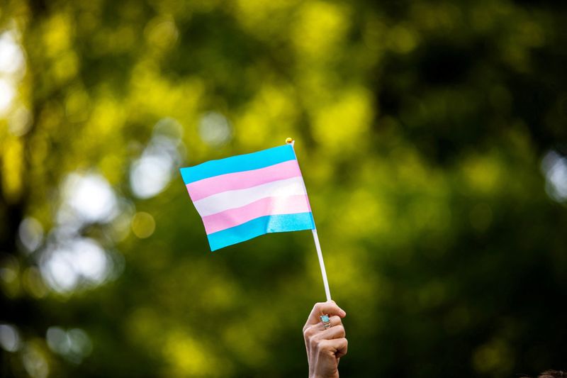 &copy; Reuters. FILE PHOTO: Transgender rights activist waves a transgender flag as they protest the killings of transgender women this year, at a rally in Washington Square Park in New York, U.S., May 24, 2019. REUTERS/Demetrius Freeman/File Photo