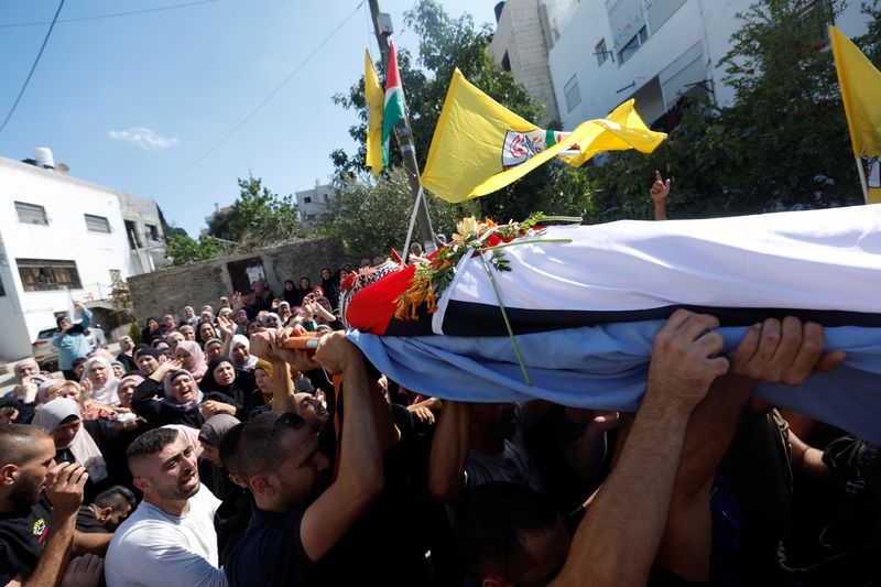 © Reuters. مشيعون يحملون جثمان شاب فلسطيني 24 عاما خلال جنازته بالقرب من رام الله في الضفة الغربية يوم الجمعة. تصوير: محمد تركمان - رويترز.
