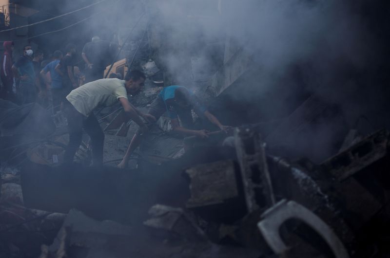 &copy; Reuters. فلسطينيون يبحثون عن مصابين وسط الحطام في أعقاب القصف الإسرائيلي في مدينة خان يونس جنوب قطاع غزة يوم السبت. تصوير: محمد سالم - رويترز.