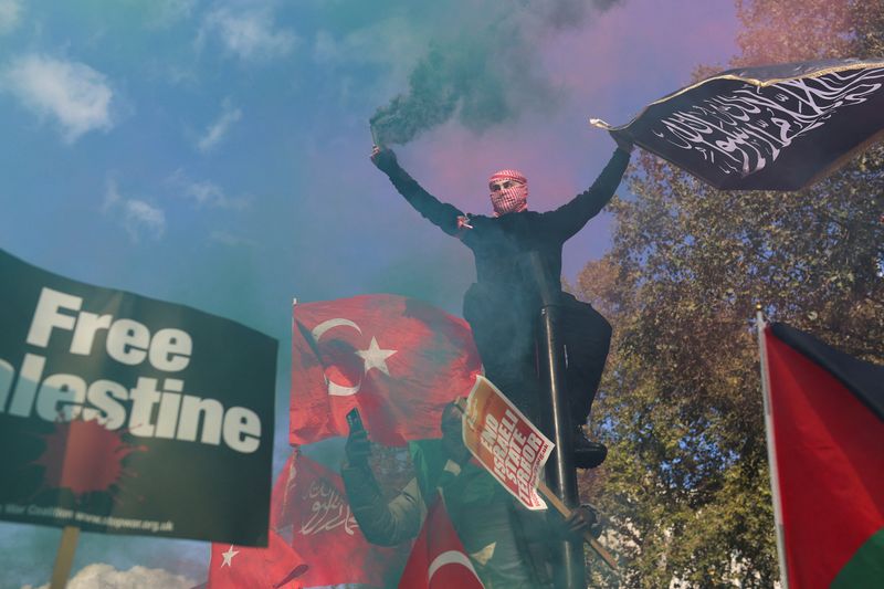 &copy; Reuters. متظاهرون يشاركون في مسيرة في لندن وأحدهم يحمل علما كتب عليه "فلسطين حرة" يوم السبت تضامنا مع الفسطينيين في أعقاب الصراع الدائر مع القوات الإ