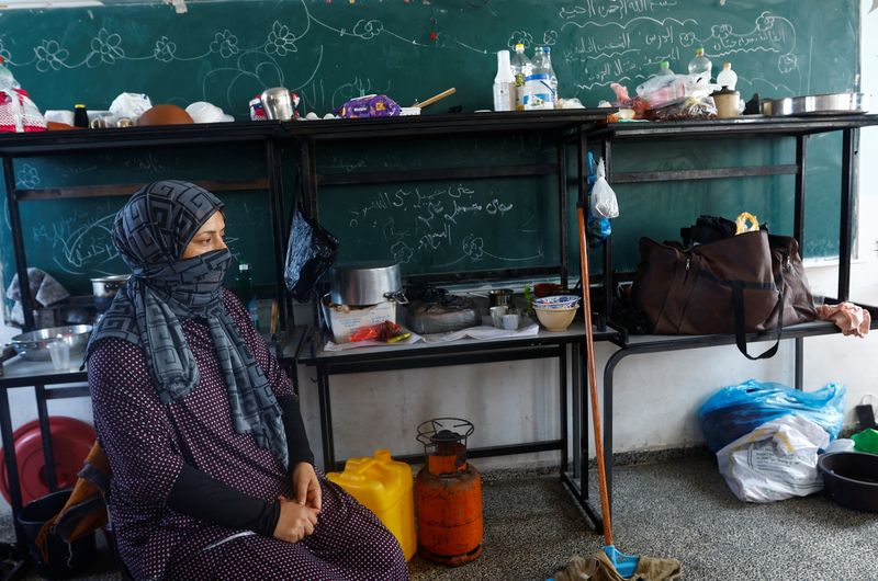 &copy; Reuters. امرأة فلسطينية فرت من منزلها تتخذ مأوى داخل مدرسة تديرها الأمم المتحدة في حي خان يونس جنوب قطاع غزة عقب دعوة إسرئيل سكان غزة لإخلاء الجزء ال