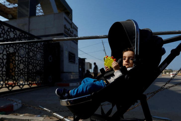 &copy; Reuters. Un niño en un carrito espera junto al paso fronterizo de Rafah, entre la Franja de Gaza y Egipto. 14 octubre 2023. REUTERS/Ibraheem Abu Mustafa