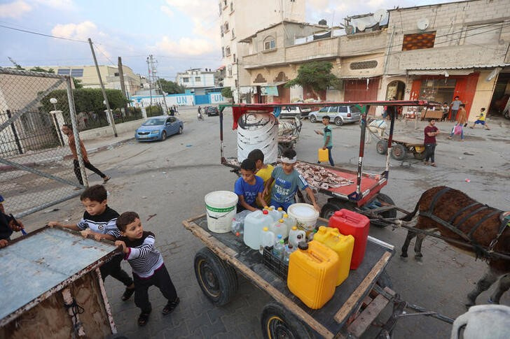 &copy; Reuters. Niños palestinos recpgen agua en Jan Yunis, en el sur de la Franja de Gaza. 14 octubre 2023. REUTERS/Ahmed Zakot