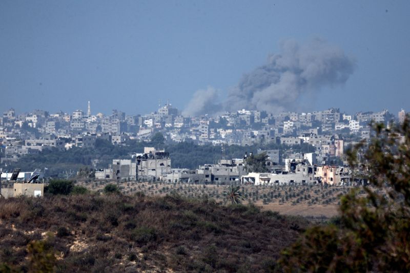 &copy; Reuters. منظر يظهر دخانا في السماء ومباني مضررة في قطاع غزة التقط من الحدود الإسرائيلية مع قطاع غزة يوم الأحد. تصوير: عامير كوهين - رويترز.