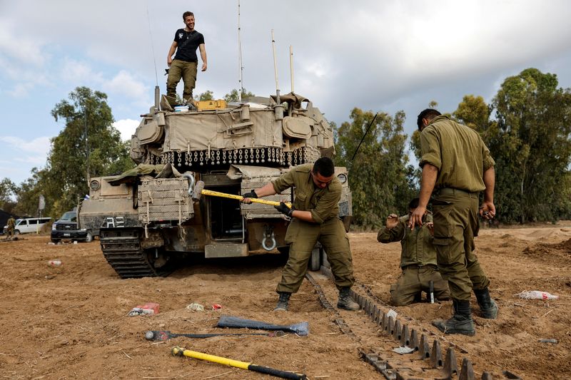 &copy; Reuters. Des soldats israéliens réparent un char près de la frontière entre Israël et la bande de Gaza. /Photo prise le 15 octobre 2023/ REUTERS/Amir Cohen