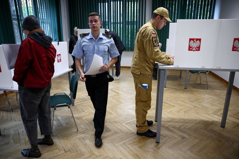 &copy; Reuters. أشخاص يدلون بصوتهم داخل مركز اقتراع خلال الانتخابات البرلمانية البولندية في وارسو يوم الأحد. تصوير: كاتسبر بيمبل - رويترز.