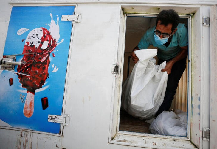 &copy; Reuters. Una persona saca de un camión de helados cadáveres de palestinos muertos en ataques israelíes en la Franja de Gaza. 15 octubre 2023. REUTERS/Stringer