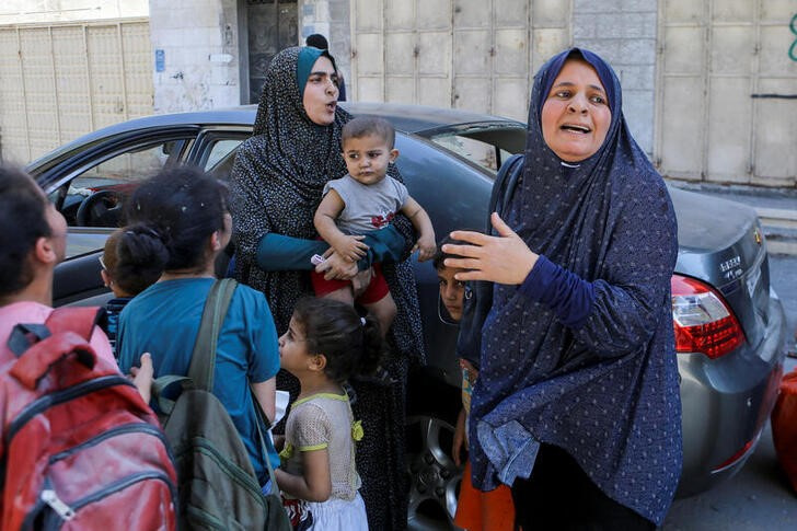 &copy; Reuters. Una familia palestina escapa tras los ataques israelíes sobre la Ciudad de Gaza. 15 octubre 2023. REUTERS/Mutasem Murtaja