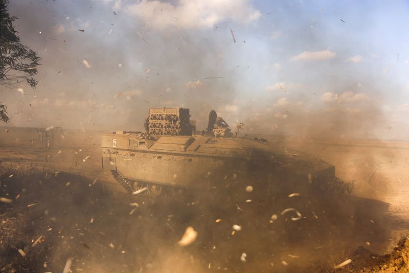 &copy; Reuters. An Israeli Armoured Personnel Carrier (APC) is obscured as it whips up dust near Israel's border with the Gaza Strip, in southern Israel October 15, 2023. REUTERS/Ronen Zvulun