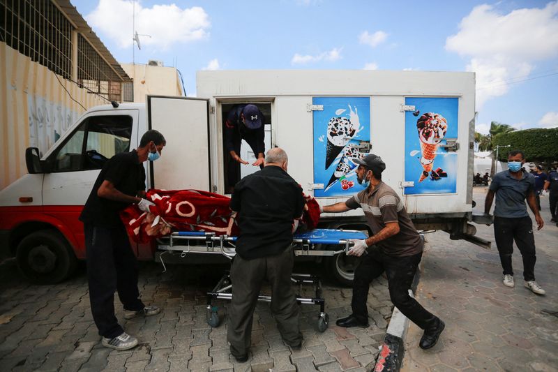 &copy; Reuters. People carry the body of a Palestinian, who was killed in Israeli strikes, from an ice cream truck where it was kept, as the hospital morgues are packed, amid the ongoing Israeli-Palestinian conflict, in the central Gaza Strip October 15, 2023. REUTERS/St