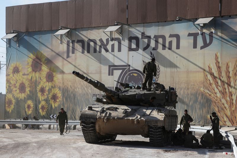 &copy; Reuters. Israeli soldiers gather on and around a tank near Israel's border with the Gaza Strip, in southern Israel October 15, 2023. REUTERS/Ronen Zvulun
