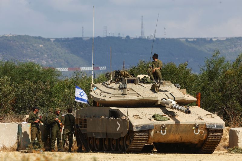 © Reuters. Israeli soldiers stand near to a tank near Israel's border with Lebanon in northern Israel, October 16, 2023. REUTERS/Lisi Niesner