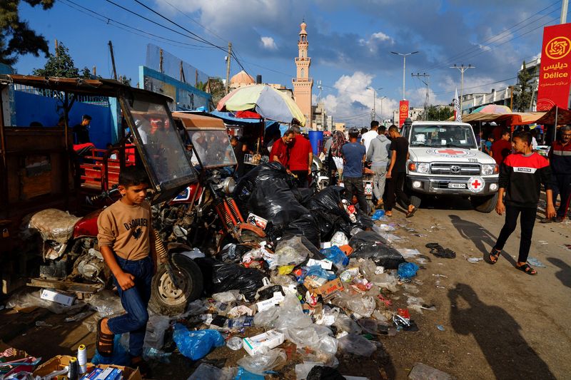 &copy; Reuters. Palestinos passam por pilhas de lixo em Gaza
 16/10/2023   REUTERS/Mohammed Salem