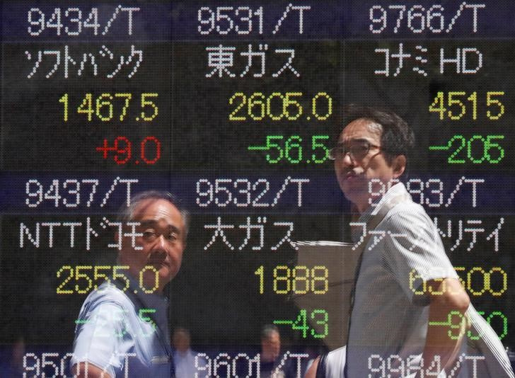 &copy; Reuters. Imagen de archivo de peatones reflejados en una pantalla con cotizaciones bursátiles en una correduría de Tokio, Japón. 6 agosto 2019. REUTERS/Issei Kato