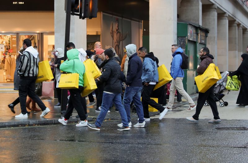 &copy; Reuters. FILE PHOTO: Pedestrians walk with shopping bags on "Black Friday" in the West End shopping district of London, Britain, November 26, 2021. REUTERS/May James/File Photo