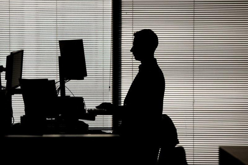 &copy; Reuters. FILE PHOTO: A man works at a computer on a standing desk in an office in the financial district of Canary Wharf in London, Britain, February 8, 2023. REUTERS/Kevin Coombs