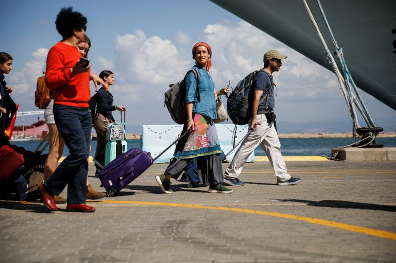 &copy; Reuters. أشخاص يحملون متعلقاتهم الشخصية قبل ركوب سفينة للمواطنين الأمريكيين وأفراد أسرهم أثناء مغادرتهم إسرائيل متجهين إلى قبرص يوم الاثنين. تصوير: