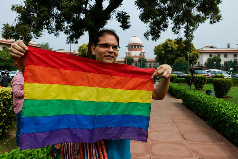 &copy; Reuters. Un escritor y miembro de la comunidad LGBTQ+ sostiene la bandera del orgullo mientras espera a conocer la sentencia sobre el matrimonio entre personas del mismo sexo dictada por el Tribunal Supremo en Nueva Delhi, India. 17 de octubre de 2023. REUTERS/Anu