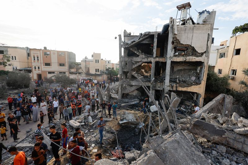 &copy; Reuters. Palestinesi cercano vittime sotto le macerie di un edificio distrutto da attacchi israeliani a Khan Younis, nel sud della Striscia di Gaza, 17 ottobre 2023. REUTERS/Mohammed Salem