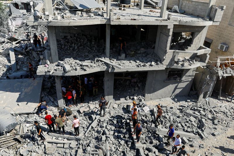 © Reuters. فلسطينيون يتجمعون في موقع مدمر جراء غارة إسرائيلية على المنازل في رفح جنوب قطاع غزة يوم الثلاثاء. تصوير: إبراهيم أبو مصطفى - رويترز.