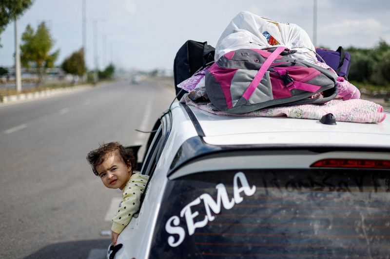 &copy; Reuters. ابنة الفلسطينية رغدة أبو مرسة،  التي فرت إلى الجزء الجنوبي من قطاع غزة بعد أمر أصدرته إسرائيل لجميع المدنيين بالتوجه جنوبا، تركب السيارة مع 