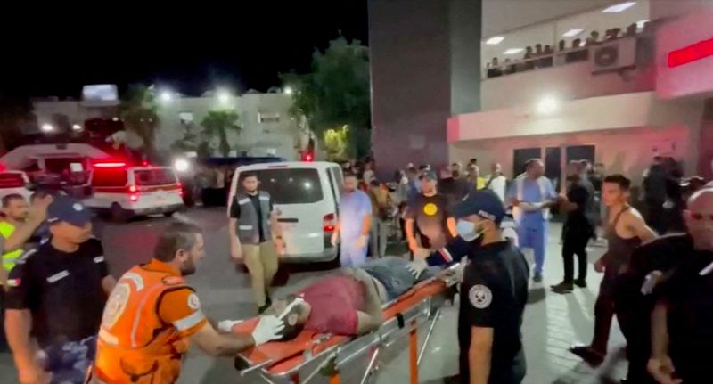 © Reuters. نقل مصاب إلى المستشفى بعد أن أصابت غارة جوية إسرائيلية مستشفى بغزة يوم الثلاثاء. تصوير: رويترز.