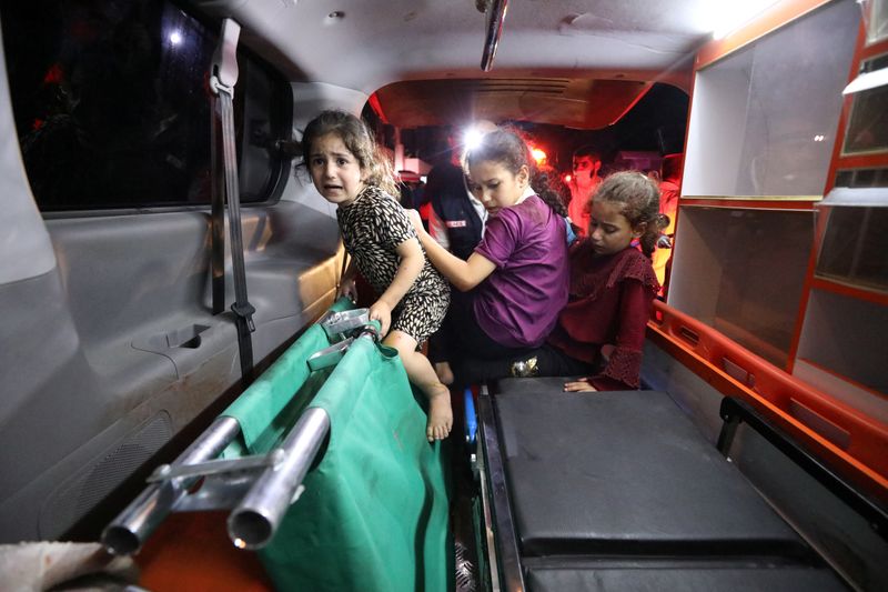 &copy; Reuters. أطفال يجلسون في سيارة إسعاف بعد أن أصابت غارة جوية إسرائيلية مستشفى في مدينة غزة يوم الثلاثاء. تصوير: محمد المصري - رويترز.
