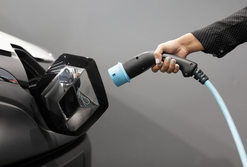 © Reuters. A woman holds a cable to charge up a Renault Kangoo ZE electric utility vehicle at a Renault automobile dealership in Cagnes-Sur-Mer, France, October 22, 2020. REUTERS/Eric Gaillard/File photo