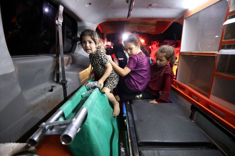 © Reuters. أطفال يجلسون داخل سيارة أسعاف بعد قصف مستشفى الأهلي المعمداني في غزة يوم الثلاثاء. تصوير: محمد المصري - رويترز.