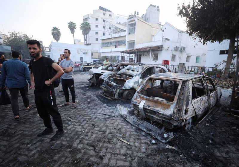 &copy; Reuters. أشخاص يعاينون منطقة مستشفى الأهلي حيث قُتل مئات الفلسطينيين في انفجار بغزة يوم الثلاثاء. تصوير: محمد المصري - رويترز.