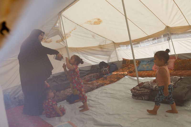 &copy; Reuters. Une femme palestinienne et ses enfants, fuyant leur domicile suite aux frappes israéliennes, s'abritent dans un centre géré par les Nations Unies après l'appel d'Israël d'évacuer plus d'un million de civils dans le nord de Gaza vers le sud, à Khan 