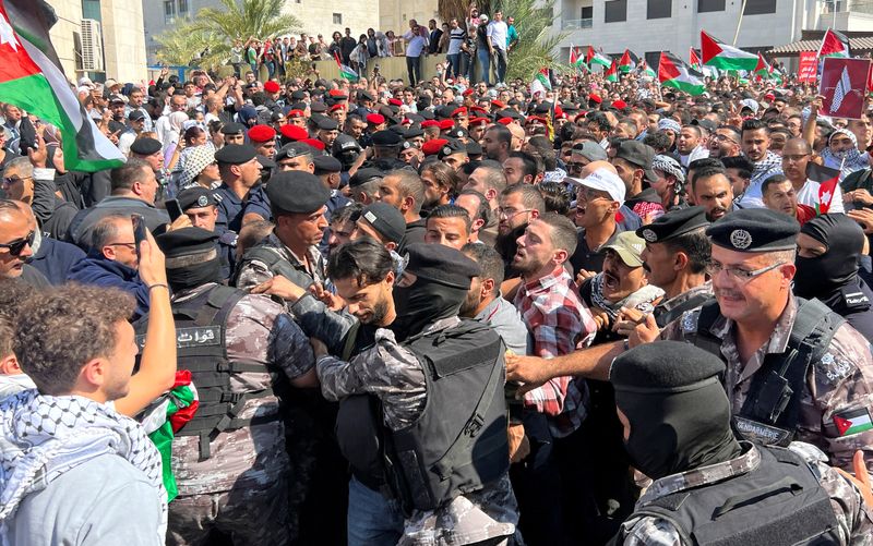 © Reuters. عناصر من الشرطة الأردنية في مواجهة مع متظاهرين أثناء محاولتهم الوصول إلى السفارة الإسرائيلية خلال احتجاج في العاصمة عمان يوم الأربعاء على الهجوم العسكري الإسرائيلي على غزة . تصوير : معاذ فريج - رويترز .