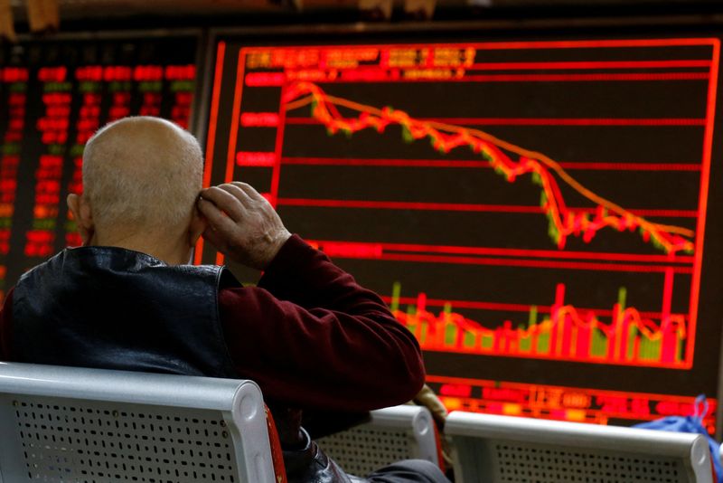 &copy; Reuters. FILE PHOTO: An investor sits in front of a board showing stock information at a brokerage office in Beijing, China, December 7, 2018.  REUTERS/Thomas Peter/File Photo