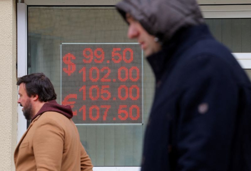 &copy; Reuters. FILE PHOTO: Pedestrians walk past an electronic board showing currency exchange rates of the U.S. dollar and euro against Russian rouble in a street in Moscow, Russia, October 6, 2023. REUTERS/Evgenia Novozhenina/File Photo