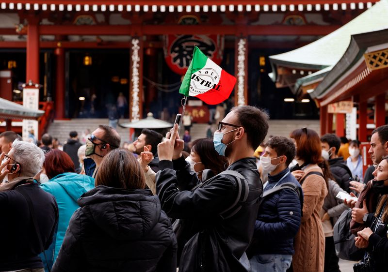 &copy; Reuters. A tour guide raises an Italian flag as she leads a tourist group from Italy, at Senso-ji temple, at Asakusa district, a popular sightseeing spot, in Tokyo, Japan, October 19, 2022. REUTERS/Issei Kato