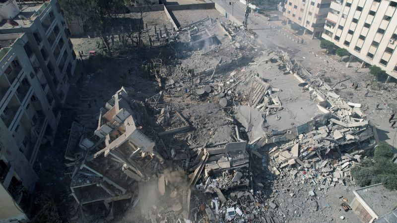 &copy; Reuters. Palestinos se reúnen alrededor de edificios residenciales destruidos en ataques israelíes en la ciudad de Zahra, en medio del conflicto en curso entre Israel y el grupo islamista palestino Hamás, en el sur de la ciudad de Gaza. 19 de octubre, 2023. REU