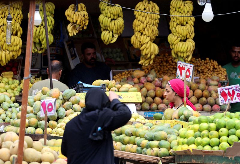 &copy; Reuters. امرأة تشتري الخضراوات والفاكهة من سوق في القاهرة يوم التاسع من أكتوبر تشرين الأول 2023. تصوير: محمد عبد الغني - رويترز.