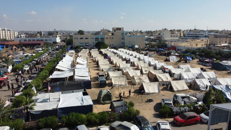 &copy; Reuters. الفلسطينيون، الذين فروا من منازلهم وسط الغارات الإسرائيلية، يحتمون في مخيم في مركز يديره الأمم المتحدة في خان يونس بجنوب غزة يوم الخميس. تص