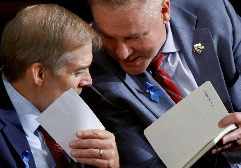 &copy; Reuters. El congresista Warren Davidson (republicano de Ohio) muestra al congresista Jim Jordan (republicano de Ohio) un cuaderno en el que se pueden leer las palabras "Cambiar o morir", mientras la Cámara de Representantes de Estados Unidos celebra la segunda ro