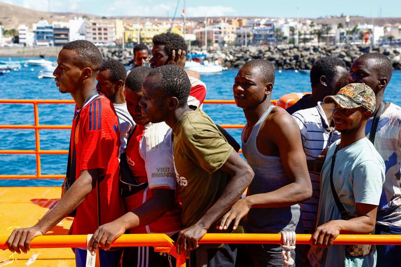 &copy; Reuters. Migrantes esperan para desembarcar de un buque guardacostas español, en el puerto de Arguineguín, en la isla de Gran Canaria, España. 19 de octubre de 2023. REUTERS/Borja Suárez