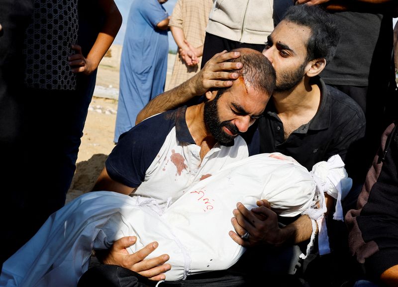 &copy; Reuters. El padre de Alma Al Majayda, de 3 años, muerta en ataques israelíes, abraza su cuerpo durante su funeral, en medio del actual conflicto entre Israel y el grupo islamista palestino Hamás, en Khan Younis, en el sur de la Franja de Gaza. 19 de octubre de 