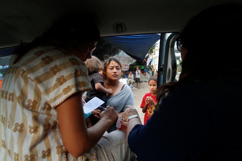 © Reuters. Midwives Leticia Serrano and Maria Abascal talk to a migrant woman carrying her son, at a makeshift migrant shelter where Serrano checks on pregnant women, in San Sebastian Tutla, Oaxaca, October 19, 2023. REUTERS/Jorge Luis Plata