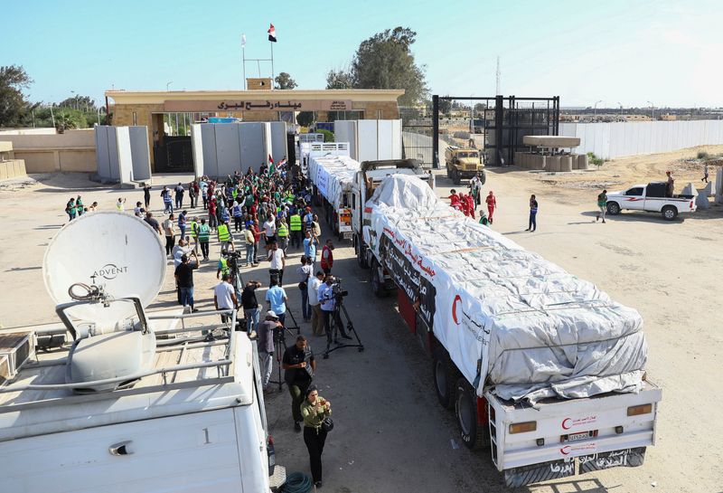 © Reuters. شاحنات تحمل مساعدات إنسانية من منظمات غير حكومية مصرية تعبر معبر رفح من الجانب المصري في رفح يوم السبت - رويترز