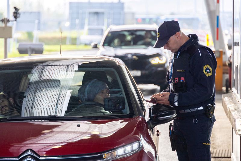 &copy; Reuters. ضابط شرطة يتفقد الوثائق عند معبر حدودي في  سلوفينيا يوم السبت. تصوير: أنطونيو برونيتش - رويترز.