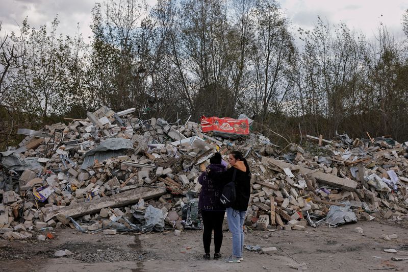 &copy; Reuters. امرأتان تقفان أمام كومة من الأنقاض جراء إصابة مقهى بصاروخ روسي في قرية هروزا في منطقة خاركيف بأوكرانيا في السادس من أكتوبر تشرين الأول 2023. ت
