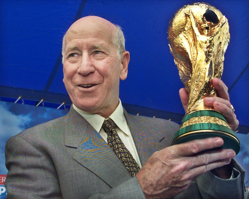&copy; Reuters. FILE PHOTO: FIFA Ambassador and England soccer legend Bobby Charlton holds up the  FIFA World Cup trophy at a kick-off of the trophy's 10-city tour of  Japan in Yokohama, venue of the World Cup final match, west of Tokyo  March 9, 2002. The trophy is to t